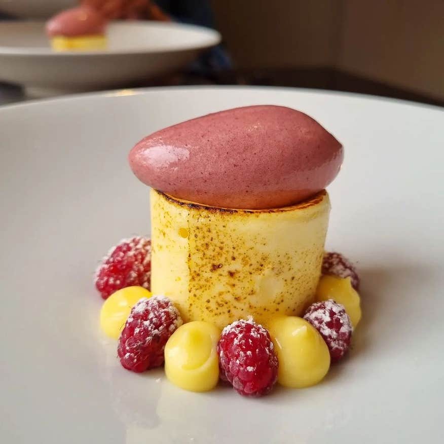 Luxurious dessert with custard and raspberry's served with a scoop of raspberry sorbet on top.
